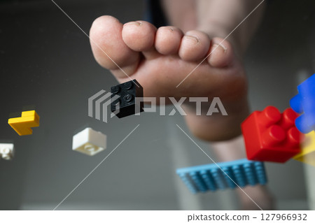 Foot Stepping on Construction Toy Bricks Creates a Messy Play Area Foot Stepping on Construction Toy Bricks Creates a Messy Play Area 127966932