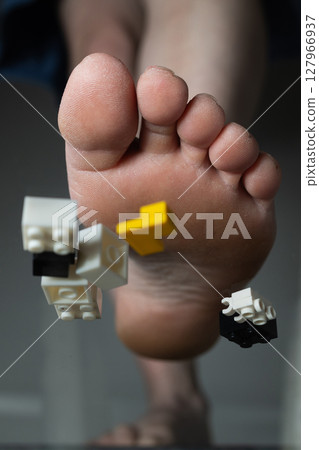 Unexpected Mess of Building Bricks Scattered Across a Foot During Playtime at Home 127966937