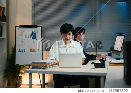 Two young businessmen working overtime in a modern office 127967205