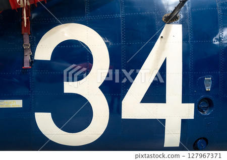 Blue aircraft fuselage with white number 34 and metal details 127967371