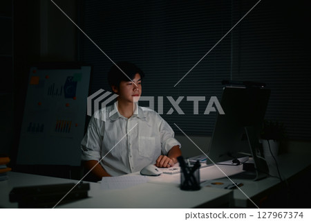 Focused businessman staying late to complete important projects,in a dimly lit office. Focused businessman staying late to complete important projects,in a dimly lit office. 127967374