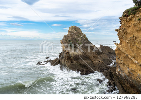 Rocky formation in the Atlantic Ocean with visible erosion patterns and waves crashing 127968285
