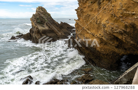 Coastal rocks and yellow cliff at the Atlantic shore 127968288