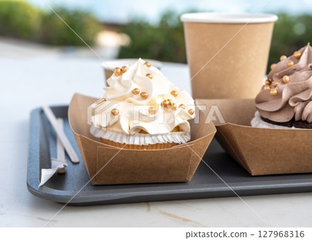 Creamy and chocolate cupcake decorated with golden balls, cup cakes with whipped cream 127968316