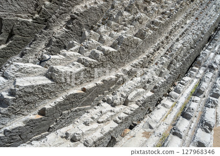 Layered rocks, flysch texture background. Sedimentary rock, striations stone pattern Layered rocks, flysch texture background. Sedimentary rock, striations stone pattern 127968346