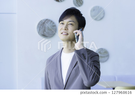一位中年男子正在用智慧型手機通話。拍攝合作:SKY Perfect Tokyo Media Center 一位中年男子正在用智慧型手機通話。拍攝合作:SKY Perfect Tokyo Media Center 127968616