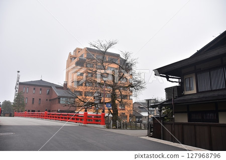 Gifu Prefecture, Japan: During the spring Takayama Festival, the tourist attraction Nakabashi Bridge and cherry blossoms in bud, the surrounding streets and old houses 127968796