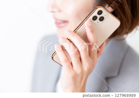 一位身穿灰色西裝的中年女子正在用智慧型手機聊天 127968989