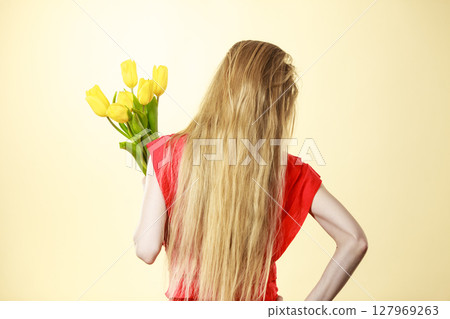 Woman wearing dress holding tulip Woman wearing dress holding tulip 127969263