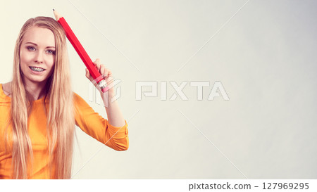 Woman holding big pencil Woman holding big pencil 127969295