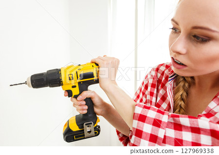 Woman having troubles using drill Woman having troubles using drill 127969338