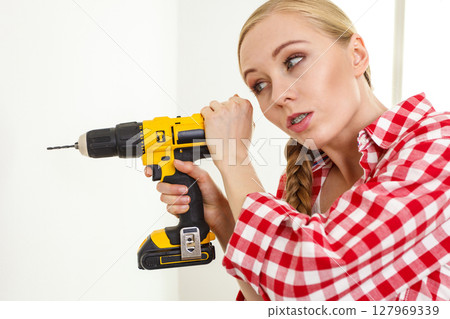 Woman having troubles using drill Woman having troubles using drill 127969339