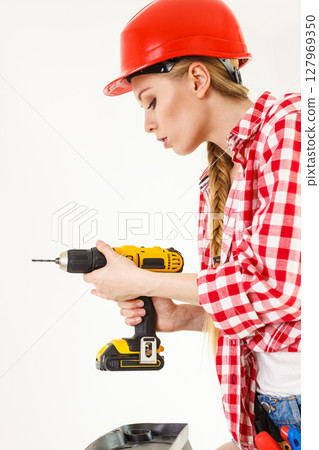Woman using drill on ladder Woman using drill on ladder 127969350