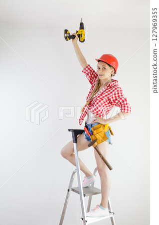 Girl using some power tools for work at home Girl using some power tools for work at home 127969355