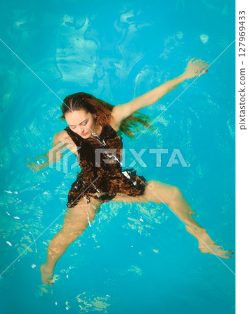 Woman floating relaxing in swimming pool water. Woman floating relaxing in swimming pool water. 127969433