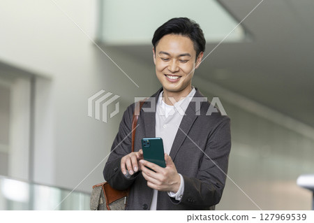 A smiling man in his 40s operating a smartphone A smiling man in his 40s operating a smartphone 127969539