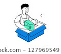 A cheerful man in uniform working on packing order into blue carton box, handling parcel for shipping delivery logistics with smiling expression 127969549