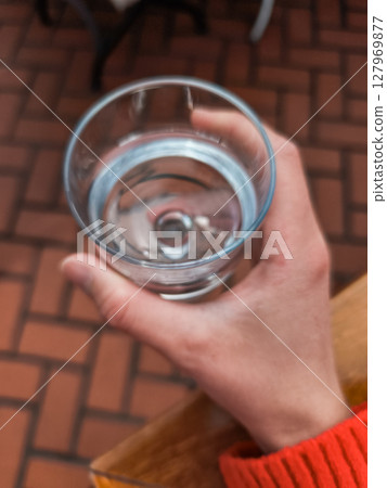 Woman holding a glass of water in prague restaurant 127969877