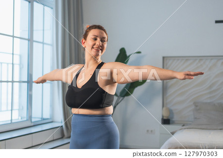 Fitness workout training. Woman practicing fitness at home. Plus size female doing sports exercise at home indoor. Girl in sportswear have workout weight training for weight loss. Sport and fitness 127970303