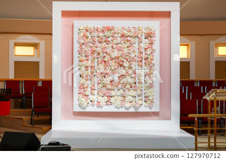 Location for the wedding ceremony. square Arch for wedding ceremony a is decorated with pink and white roses and peonies flowers. Wedding decor inside banquet area. Location for the wedding ceremony. square Arch for wedding ceremony a is decorated with pink and white roses and peonies flowers. Wedding decor inside banquet area. 127970712