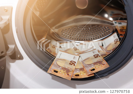 Euro money banknotes in washing machine - illegal cash 50 and mafia money laundering - tax evasion in Europe inflation and impairment. money laundering concept - euro banknotes in washing mashine 127970758
