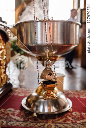 selective focus. A priest's censer hangs on an old wall in the Orthodox Church. Copper incense with burning coal inside. Service in the concept of the Orthodox Church. Adoration 127970764