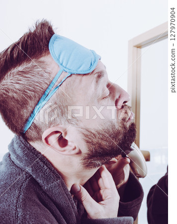 Man shaving trimming his beard Man shaving trimming his beard 127970904