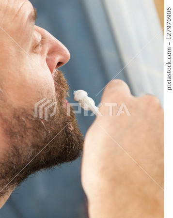 Man brushing his teeth in bathroom Man brushing his teeth in bathroom 127970906