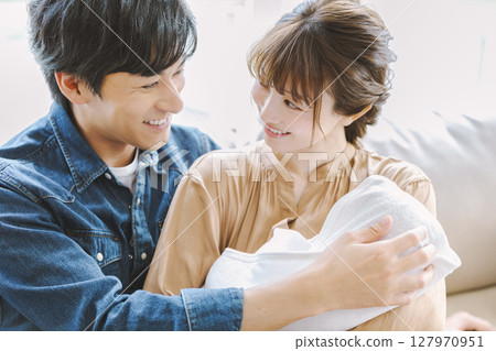 爸爸媽媽抱著一個嬰兒 爸爸媽媽抱著一個嬰兒 127970951