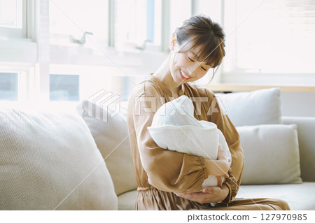 一個年輕的媽媽抱著一個孩子 一個年輕的媽媽抱著一個孩子 127970985