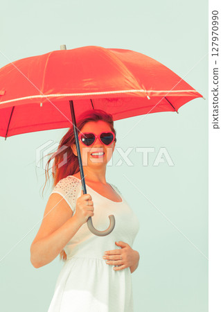 Portrait of redhead adult woman holding umbrella 127970990