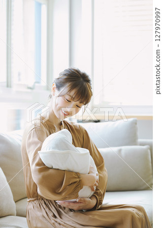 一個年輕的媽媽抱著一個孩子 127970997