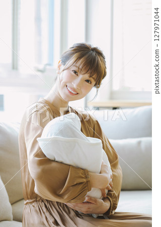 一個年輕的媽媽抱著一個孩子 127971044