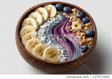 Delicious breakfast. Colorful acai bowl with banana slices, coconut flakes and granola on a white background.  Healthy and Wellness Breakfast for luxury resorts. 127971089