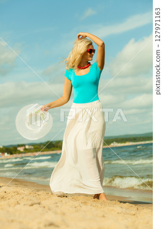 Beautiful blonde girl in hat on beach 127971163
