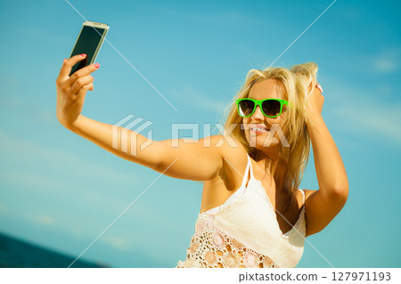 Happy girl taking self picture with smartphone 127971193