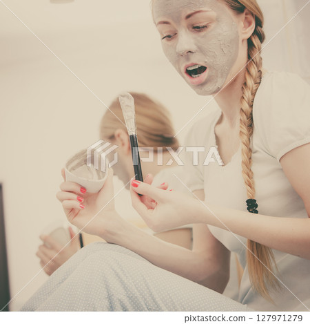 Woman with grey clay mud mask on her face 127971279