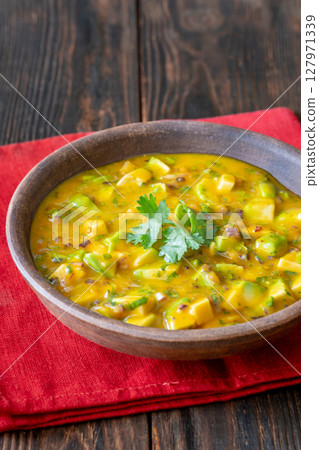 Rustic bowl of mango salsa bursting with color and fresh tropical flavor 127971339