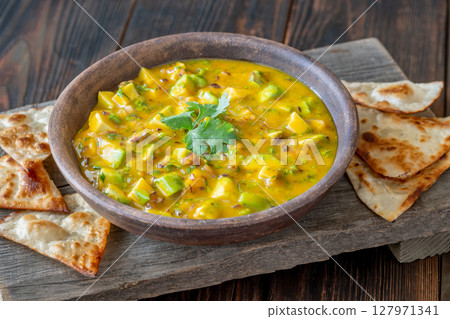 Fresh mango salsa served with tortilla chips in rustic wooden food setting 127971341