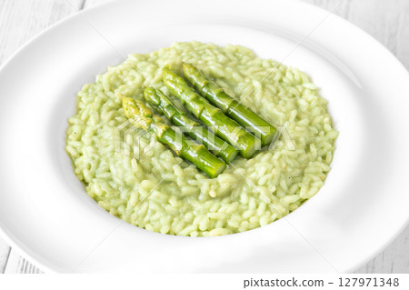 Asparagus risotto served in white plate with whole spears on top Asparagus risotto served in white plate with whole spears on top 127971348