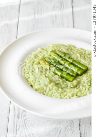 Asparagus risotto served in white plate with whole spears on top Asparagus risotto served in white plate with whole spears on top 127971349