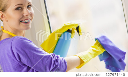 Girl cleaning window at home Girl cleaning window at home 127971440