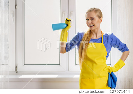 Woman cleaning window at home 127971444