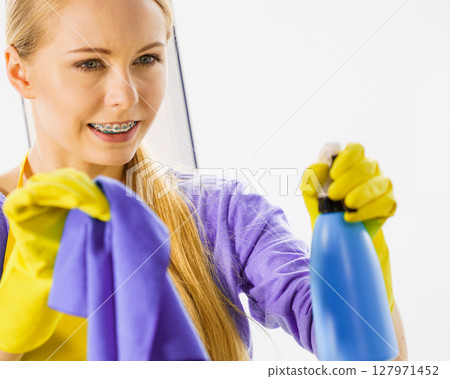 Girl cleaning window at home 127971452