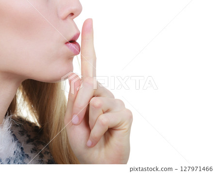 Woman making silence gesture with finger Woman making silence gesture with finger 127971466