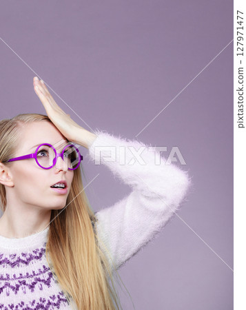 Nerd blonde woman holding hand on forehead Nerd blonde woman holding hand on forehead 127971477