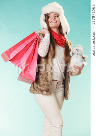Winter woman with little snowman and bags shopping 127971569