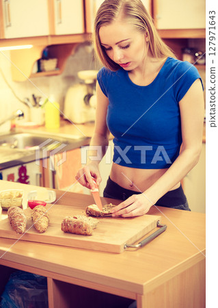 Woman preparing healthy breakfast making sandwich 127971643