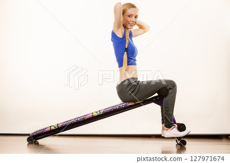 Woman training on bench for sit ups 127971674