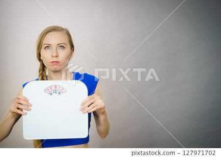 Teenage woman holding bathroom scale machine 127971702